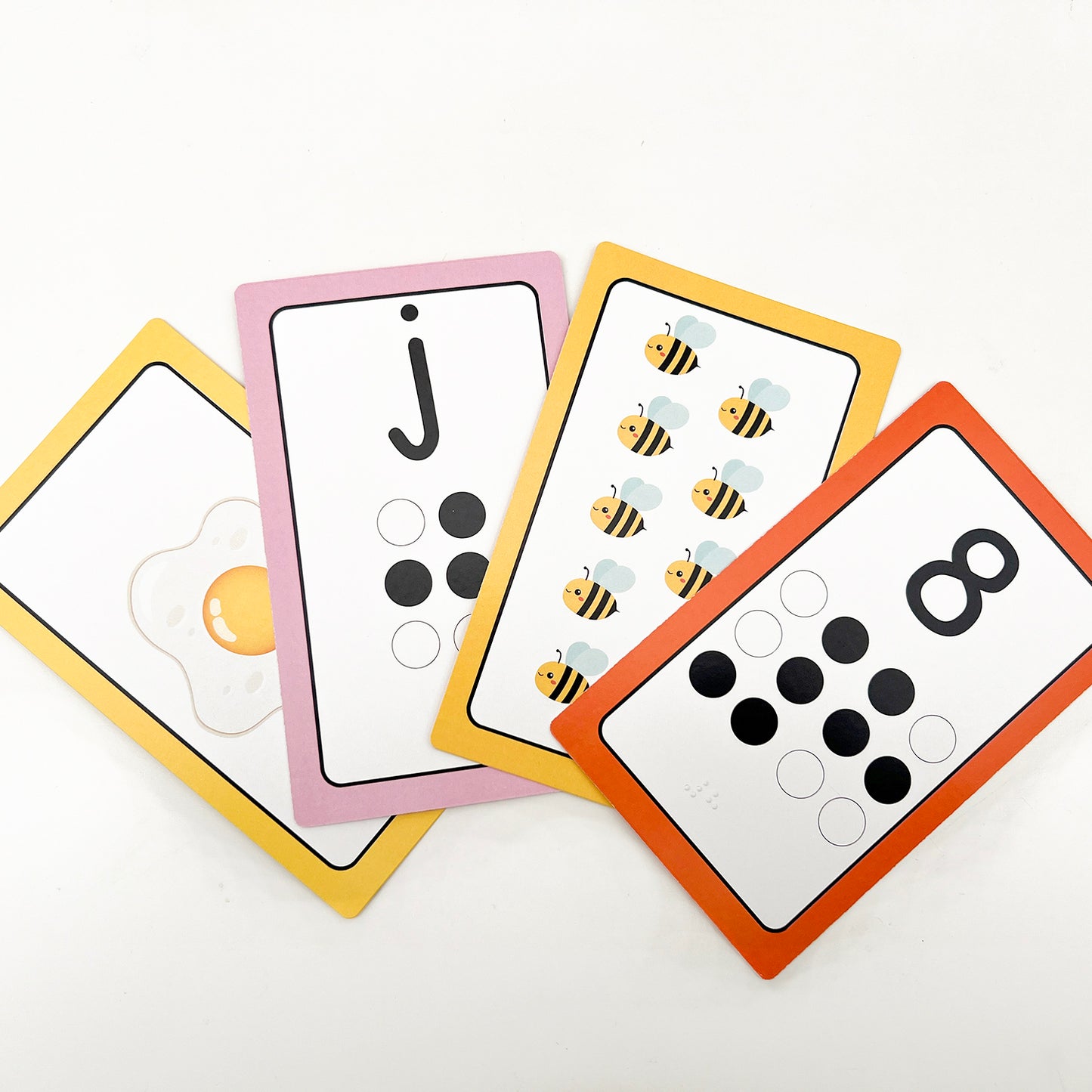 Flashcards showing an egg, the letter j, 10 bees and the number eight.