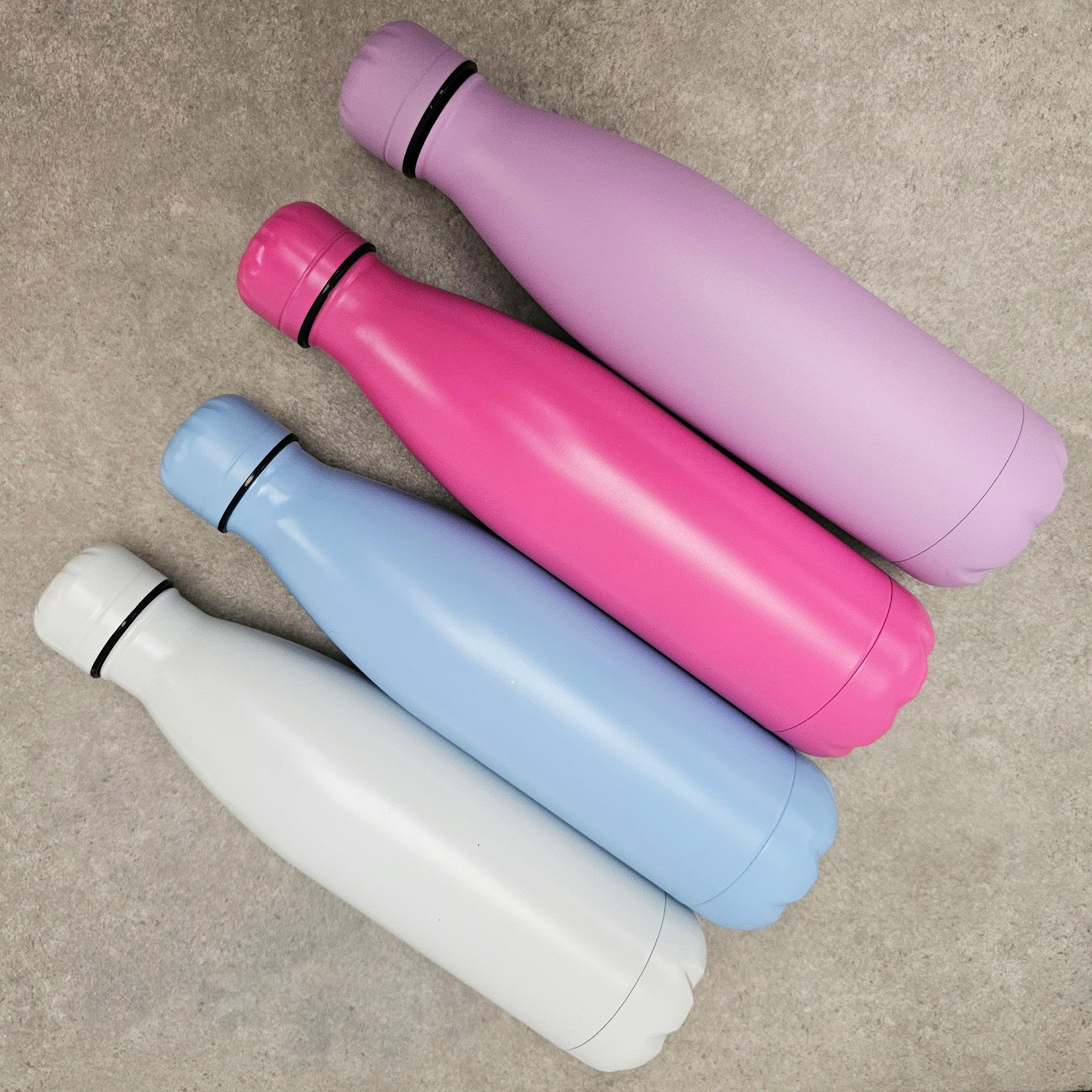 White, blue, pink and purple water bottles.